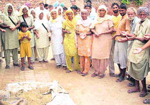 Residents of Nadel village in Fatehabad district with the rotten wheat 