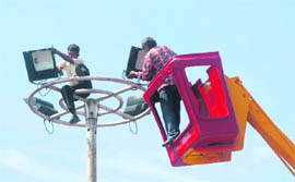 Workers of the Power Development Department change bulbs of mastlights at Shaheedi Chowk in Jammu