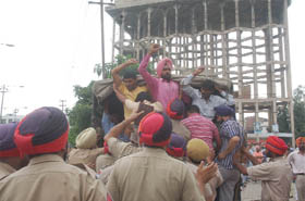 Cops take away protesting unemployed multi-purpose health workers near Gol Diggi in Bathinda on Saturday