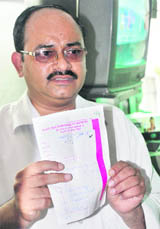 John David shows the card bearing visitor number 154 at the OPD of the GMSH in Chandigarh on Saturday.
