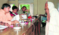 Chief Parliamentary Secretary Dharam Vir listens to an elderly womans grievances at a meeting in Karnal on Saturday