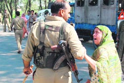 A woman, whose son was allegedly picked up by the police for stone throwing, argues with a policeman in Srinagar on Saturday.