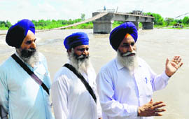 Villagers stand in front of a bridge being built on the Sutlej near Burj village. 