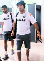 Yuvraj Singh (R) and Munaf Patel (L) leave the ground as rain suspends the teams training session in Dambulla on Saturday