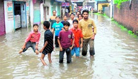 Children enjoy waterlogging on a street in Dehradun on Sunday.