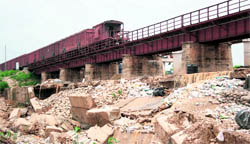 A train crosses the damaged railway bridge over the Balole Nullah in Bari Brahmana in Samba district on Sunday