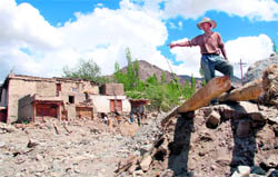 Tashi Tundup, a relative of Yutsu of Saboo village, shows the damaged house in which the entire family of Yutsu was washed away