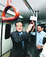 Japanese Foreign Minister Katsuya Okada rides in the Metro in New Delhi on Sunday.