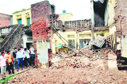 A team of doctors inspects the house that collapsed during heavy rain at Hallo Majra village in Chandigarh 