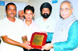 Coach Pravesh Sharma being honoured in Dehradun on Monday. 
