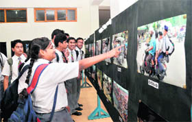 Students look at pictures at an exhibition put up by city-based photographers in Dehradun on Monday.