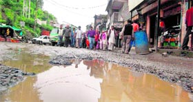 Commuters avoid the damaged road stretch in Kufri near Shimla on Monday.
