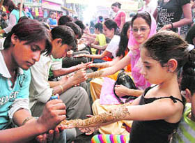 Girls and women get mehndi applied on their hands in Dehradun on Tuesday.
