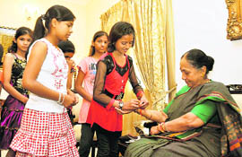Students tie rakhis on the hands of Uttarakhand Governor Margaret Alva at the Raj Bhawan in Dehradun on Tuesday.