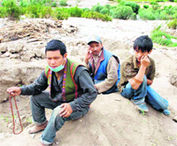 Tsewang Phunchak, who lost three members of his family in flash floods, sits on the rubble of his two-storeyed house in Ney village