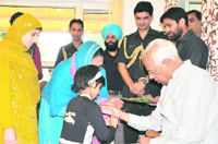 A girl from SOS Childrens Village ties a rakhi on the wrist of Governor NN Vohra in Srinagar 