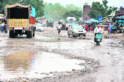 A stretch of the Jammu-Pathankot National Highway, which is in bad shape, welcomes tourists at Lakhanpur on the states border with Punjab
