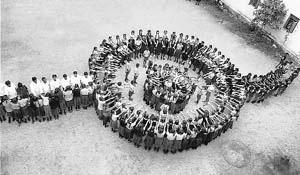 Schoolchildren make a human chain in the shape of a Rakhi on the occasion of Raksha Bandhan in Chikmagalur on Tuesday.