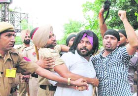 District Youth Congress (Rural) president Vikramjit Singh Chaudhary is detained by the police after he showed a black flag to Deputy CM Sukhbir Badal during his visit to Jalandhar