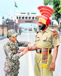 A BSF recruit ties a rakhi to her colleague at the Attari-Wagah joint checkpost