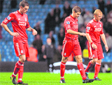 Liverpool players walk back after losing to Manchester City 