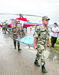 Nepali soldiers carry the remains of crash victims at the domestic airport in Kathmandu on Tuesday
