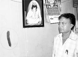 A shopkeeper shows the demarcation sign marked by the M
