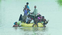 Residents move with their household goods after the Yamuna water rose above the danger level