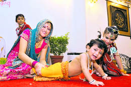 A mother tries to hold her son at a Janamashtami programme organised by the Doon Ladies Club in Dehradun on Wednesday