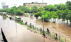 A bus plies on a flooded road near the Ring Road after heavy rain in New Delhi 