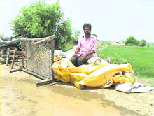 Jeet Singh, a resident of Dine Ke, takes refuge on a dhussi bundh after his village was inundated on Wednesday. 