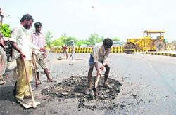 Labourers repair the recently inaugurated railway overbridge in Bathinda on Wednesday. 