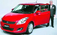 Suzuki Motor Corp CEO Osamu Suzuki poses with a remodelled Swift at its launch in Tokyo on Thursday. Suzuki said it plans to sell more than 2 million units of new Swift worldwide.