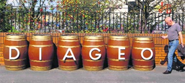 A man walks past barrels outside the Diageo Shieldhall facility near Glasgow, Scotland, on Thursday.