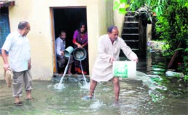 Doonites take out water from their homes in a locality in Dehradun on Thursday.