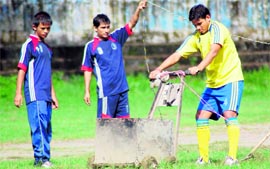 Football players trim grass at the Pavilion Grounds before their scheduled match of the day in Dehradun on Thursday.