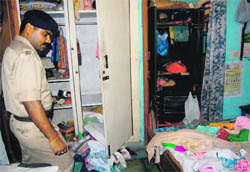 A policeman inspects the house of Madan Gopal Bansal. 