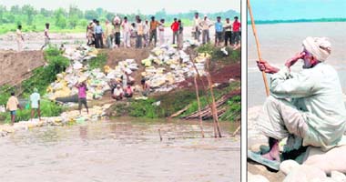 Labourers try to plug a breach in the Yamuna embankment in Mustafabad in Karnal for the second day on Thursday even as a despondent farmer looks on