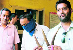 Barinder Singh (face covered) in police c