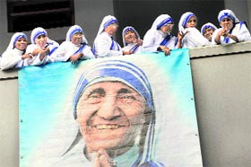 Nuns of the Missionaries of Charity during the service to mark the 100th birth anniversary of Mother Teresa (pictured in banner) at her tomb in Kolkata on Thursday.