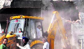 An illegal construction removed during the MC anti-encroachment drive near the railway flyover at Dera Bassi on Friday.