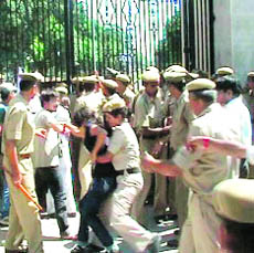 A police woman tries to overpower an SFI activist at Kurukshetra University on Friday.