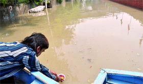 A devotee offers puja at the flooded Yamuna at Kudsia Ghat near ISBT in New Delhi on Saturday. The rivers level continued to rise.
