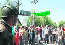 A jawan stands guard as protesters shout slogans after defying curfew at Hyderpora on the outskirts of Srinagar on Saturday.
