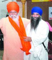 Damdami Taksal chief Harnam Singh Khalsa (right) presents a siropa to Baba Mahinder Pal after a seminar on Guru Granth Sahib and Amrit Bani in Jalandhar on Sunday. 