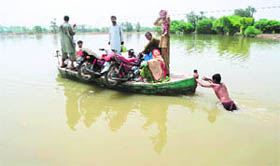Pakistani flood survivors sit on a boat as they return to their homes in Shah Jamal on Sunday.