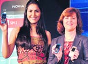 Nokia executive VP Mary McDowell (R) along with a model display dual-sim mobile phones at thier launch in New Delhi on Monday. Nokia India launched two new mobile handsets, Nokia C-1 and C-2, priced at 