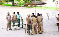 PU GARRISONED: Police personnel relax at the Student Centre in Panjab University, Chandigarh, on Monday. No student was in sight during the ongoing election campaign