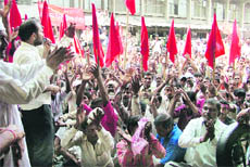 Workers of power loom units hold a protest outside the labour office in Ludhiana on Monday.