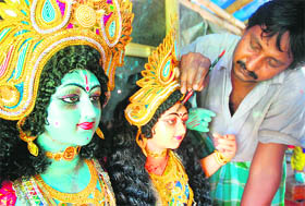 An artist gives final touches to idols of Krishna on the eve of Janmashtami at Kali Bari temple, near Air Force station, in Chandigarh.